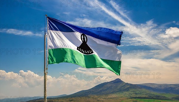 The flag of Lesotho, fluttering in the wind, isolated, against the blue sky