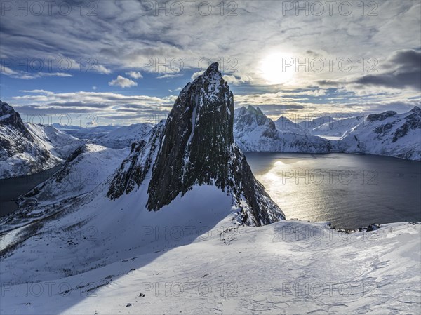 Aerial view of Bergen by the sea, fjord, sunbeams, winter, snow, Mount Segla, Senja, Troms, NorwayDefault