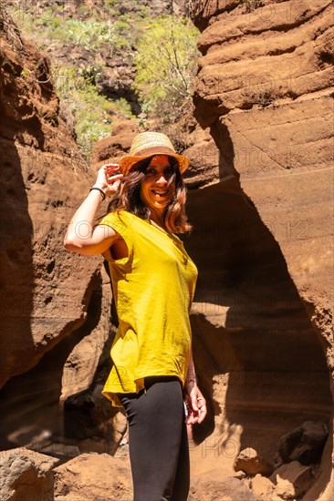 Portrait of a woman with hat in the limestone canyon Barranco de las Vacas in Gran Canaria, Canary Islands