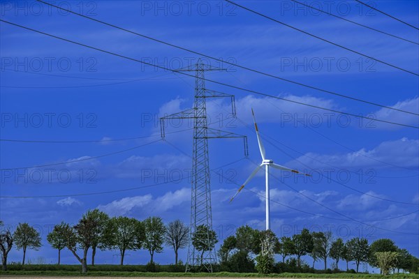 Electricity pylon with high-voltage lines and wind turbine on the K63 road with trees at the Avacon substation Helmstedt, Helmstedt, Lower Saxony, Germany, Europe