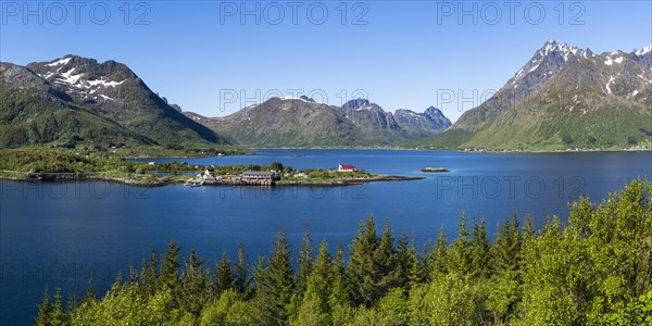 Landscape on the Lofoten Islands with sea and mountains. The Sildpollnes peninsula in the Austnesfjord with a church, a few houses and the Sjocamp campsite. Good weather, blue sky. Early summer. Panoramic shot. Sildpollnes, Austvagoya, Lofoten, Norway, Europe
