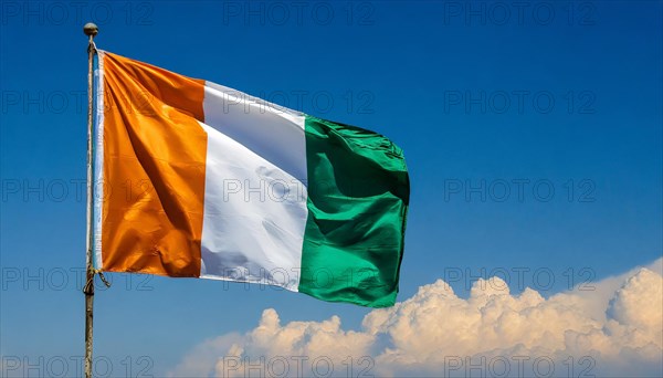 The flag of Ivory Coast flutters in the wind, isolated, against the blue sky