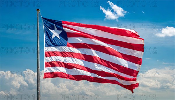 The flag of Liberia, fluttering in the wind, isolated, against the blue sky