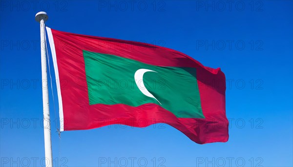 The flag of Maldives, fluttering in the wind, isolated, against the blue sky