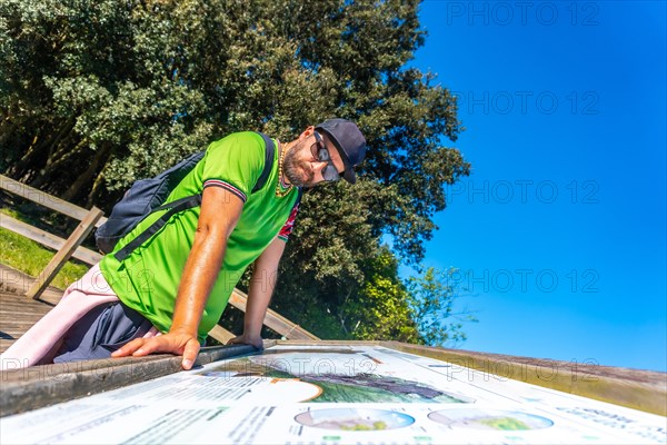 A man looking at an information panel in the Zumaia flysch, Gipuzkoa. Basque Country