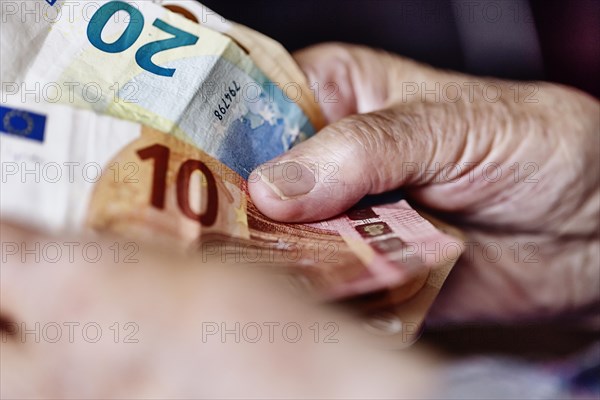 Wrinkled hands of a senior citizen with banknotes at home in her living room, close-up, Cologne, North Rhine-Westphalia, Germany, Europe