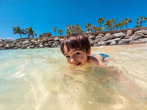 Portrait of a boy on vacation on a beach in the Canary Islands. Concept of happy family outdoors. Family vacation on the sea coast
