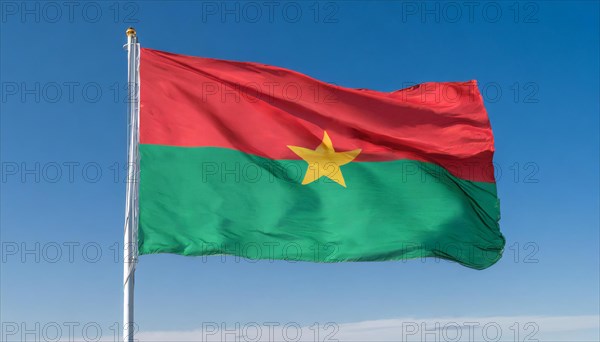 The flag of Burkina Faso flutters in the wind, isolated against the blue sky