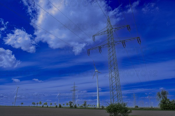 Power pylons with high-voltage lines and wind turbines on the K63 road with trees at the Avacon substation in Helmstedt, Helmstedt, Lower Saxony, Germany, Europe