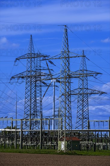 Power pylons with high-voltage lines and wind turbine at the Avacon substation in Helmstedt, Helmstedt, Lower Saxony, Germany, Europe