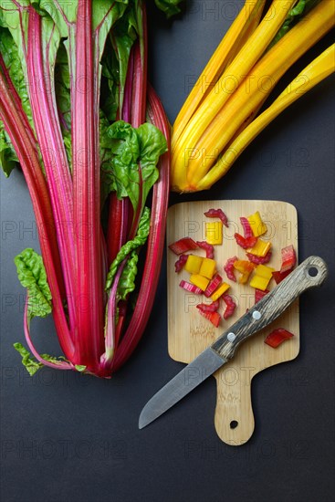 Swiss chard, chopped stems on wooden board with knife, Beta vulgaris