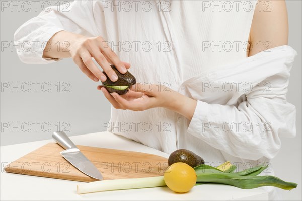 Unrecognizable woman opens avocado halves