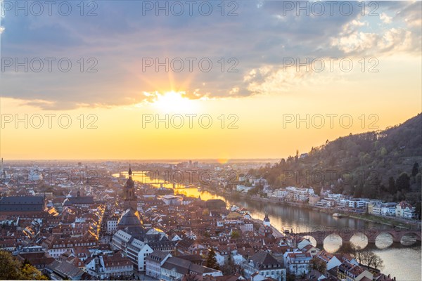 View over an old town with churches in the evening at sunset. This town lies in a river valley of the Neckar, surrounded by hills. Heidelberg, Baden-Wuerttemberg, Germany, Europe