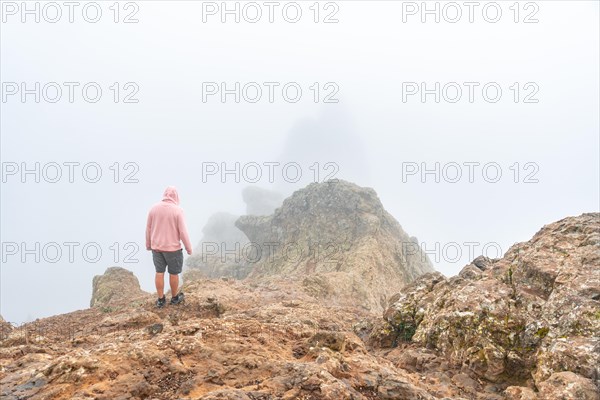 A tourist inside the fog on the very cloudy Pico de las Nieves in Gran Canaria, Canary Islands. Spain