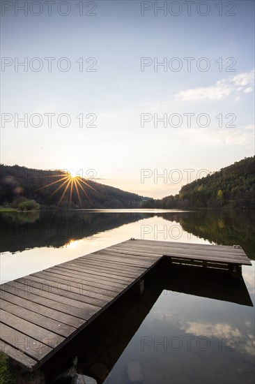 Lake at sunset. Beautiful landscape, taken from the shore of a reservoir. Situated in the middle of the forest and surrounded by nature, the reservoir offers a great atmosphere. Marbach Reservoir, Odenwald, Hesse, Germany, Europe