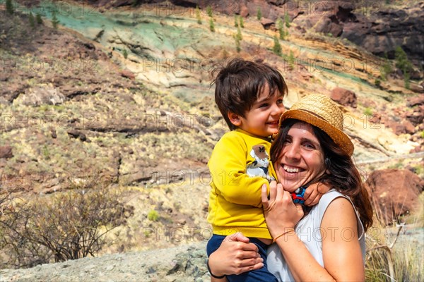 Family of mother and son enjoying at the Natural Monument Azulejos de Veneguera or Rainbow Rocks in Mogan, Gran Canaria