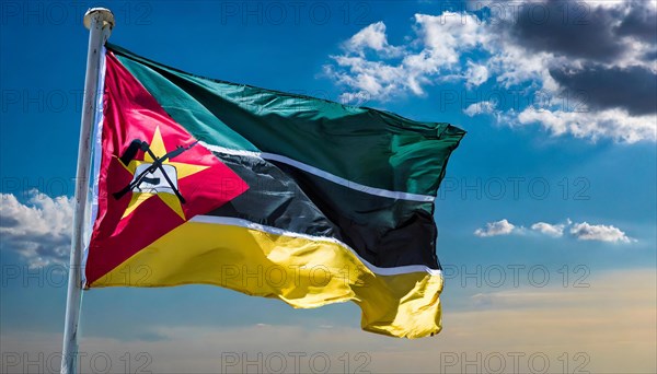 The flag of Mozambique, fluttering in the wind, isolated, against the blue sky