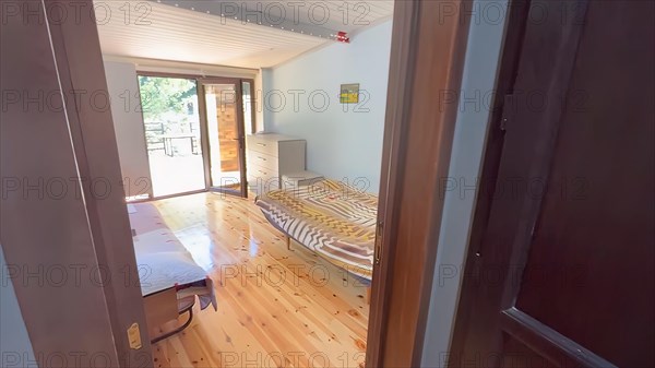 Interior of a bedroom with hardwood floor and wooden bed