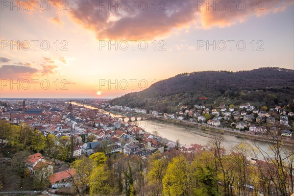 View over an old town with churches in the evening at sunset. This town lies in a river valley of the Neckar, surrounded by hills. Heidelberg, Baden-Wuerttemberg, Germany, Europe