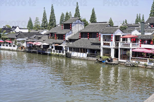 Excursion to Zhujiajiao water village, Shanghai, China, Asia, Wooden boat on canal with views of historic architecture, Traditional buildings with red accents along a tranquil river, Asia