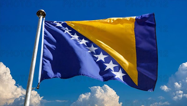 The flag of Bosnia and Herzegovina flutters in the wind, isolated against a blue sky