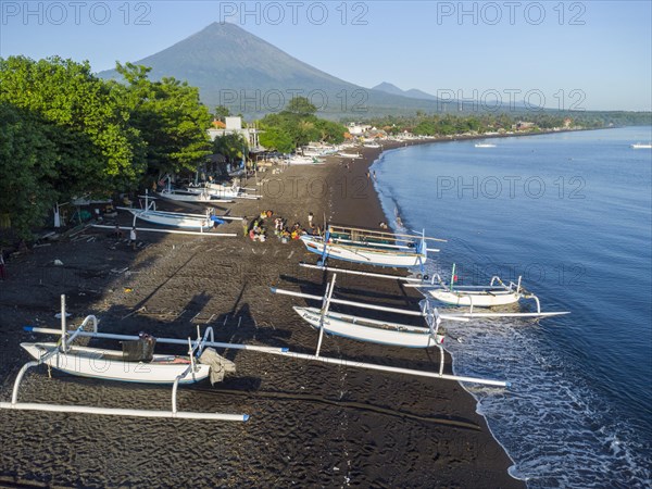 Fishermen loading fish from their outrigger boats in the morning on the black beach of Amed, Amed, Karangasem, Bali, Indonesia, Asia