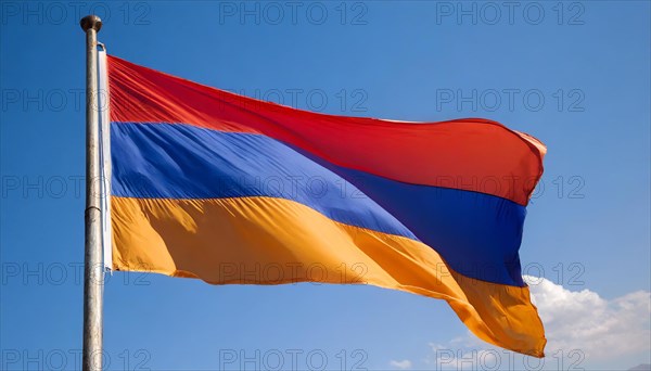 The flag of Armenia flutters in the wind, isolated against a blue sky