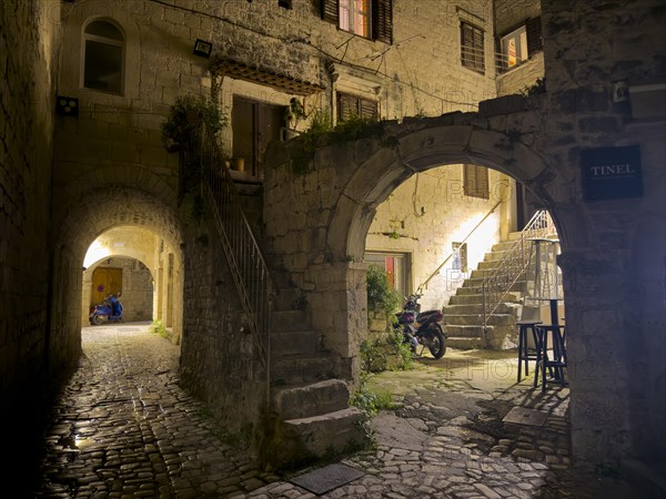 Stone arch and stairs of an old building illuminated at night, Trogir, Dalmatia, Croatia, Europe