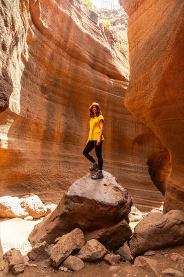 A woman in a yellow t-shirt in the limestone canyon Barranco de las Vacas in Gran Canaria, Canary Islands