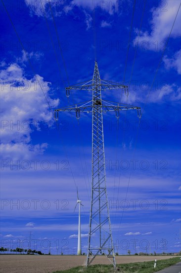 Power pylons with high-voltage lines and wind turbines at the Avacon substation in Helmstedt, Helmstedt, Lower Saxony, Germany, Europe