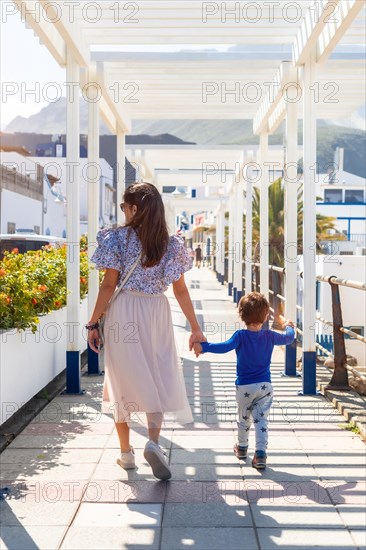 A mother with her son walking on holiday in Puerto de Las Nieves in Agaete on Gran Canaria, Spain, Europe