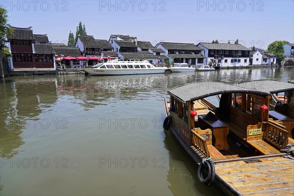 Excursion to Zhujiajiao water village, Shanghai, China, Asia, wooden boat on canal with views of historic architecture, river landscape with boats, traditional houses and clear blue sky, Asia