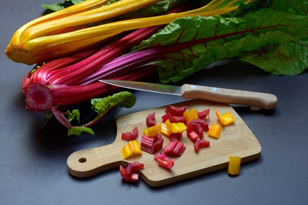 Swiss chard, chopped stems on wooden board with knife, Beta vulgaris