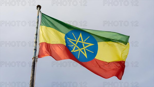 The flag of Ethiopia, fluttering in the wind, isolated against a blue sky