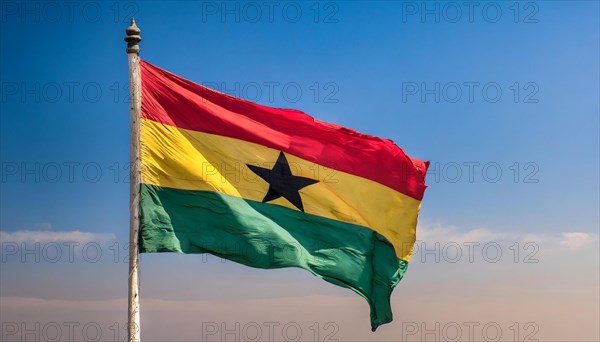 The flag of Ghana flutters in the wind, isolated against a blue sky