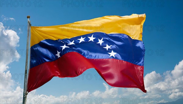 The flag of Venezuela, fluttering in the wind, isolated against a blue sky