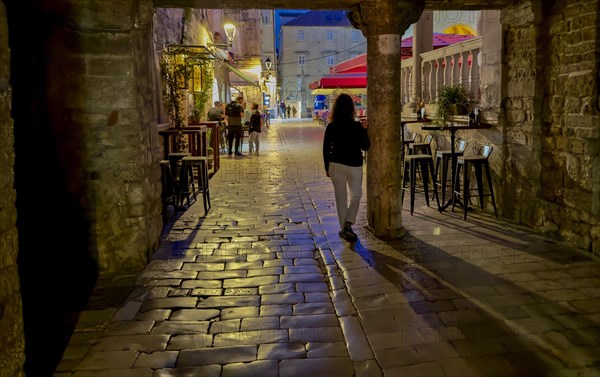 Person walking along a cobblestone street at night, Trogir, Dalmatia, Croatia, Europe