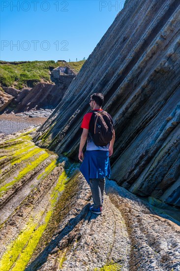 A male hiker visiting the Flysch Basque Coast geopark in Zumaia without people, Gipuzkoa