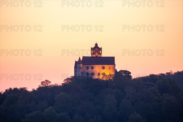 Landscape at sunrise. Beautiful morning landscape with fresh yellow rape fields in spring. Small castle in the yellow fields on a hill. Historic Ronneburg Castle in the middle of nature, Ronneburg, Hesse, Germany, Europe