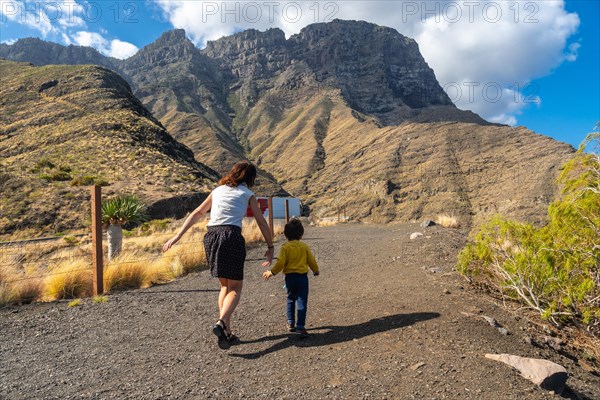 A mother and her son walking and having fun in the mountains of the Agaete coast, Roque Guayedra, Gran Canaria