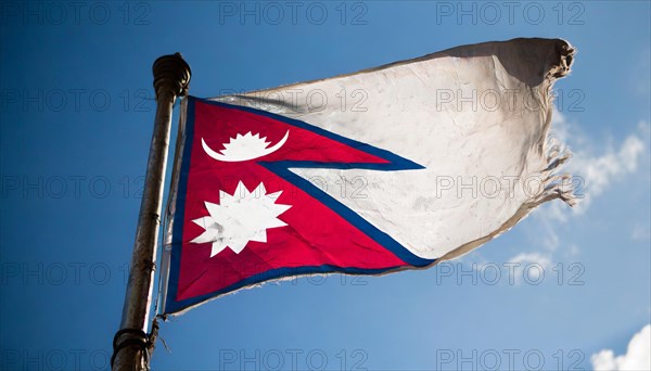 The flag of Nepal, fluttering in the wind, isolated against a blue sky