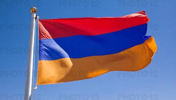 The flag of Armenia flutters in the wind, isolated against a blue sky