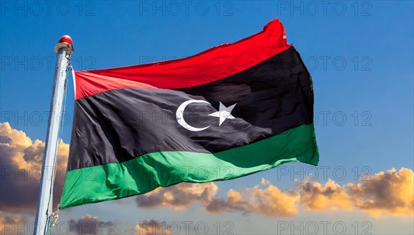 The flag of Libya, fluttering in the wind, isolated, against the blue sky