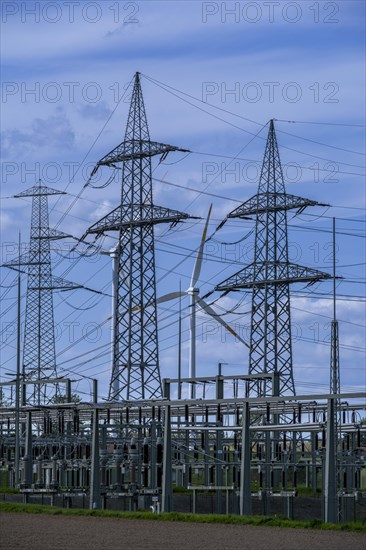 Power pylons with high-voltage lines and wind turbine at the Avacon substation in Helmstedt, Helmstedt, Lower Saxony, Germany, Europe