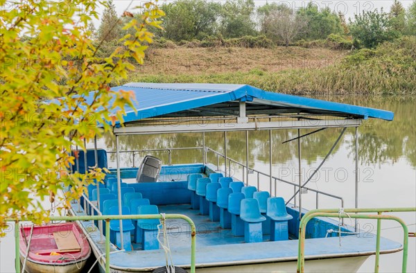 Old flat bottom tour boat moored at riverside dock in wilderness park in South Korea
