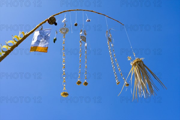 Artfully woven palm leaf jewellery on bamboo poles, on a village street in Amed, Karangasem, Northeast Bali, Indonesia, Asia