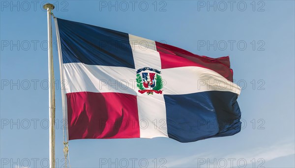 The flag of the Dominican Republic flutters in the wind, isolated against a blue sky