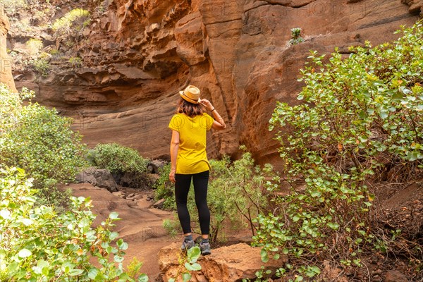 A woman tourist in the limestone canyon Barranco de las Vacas in Gran Canaria, Canary Islands