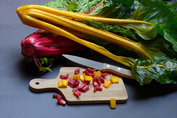 Swiss chard, chopped stems on wooden board with knife, Beta vulgaris