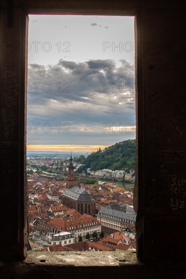 View over an old town with churches in the evening at sunset. This town lies in a river valley of the Neckar, surrounded by hills. Heidelberg, Baden-Wuerttemberg, Germany, Europe